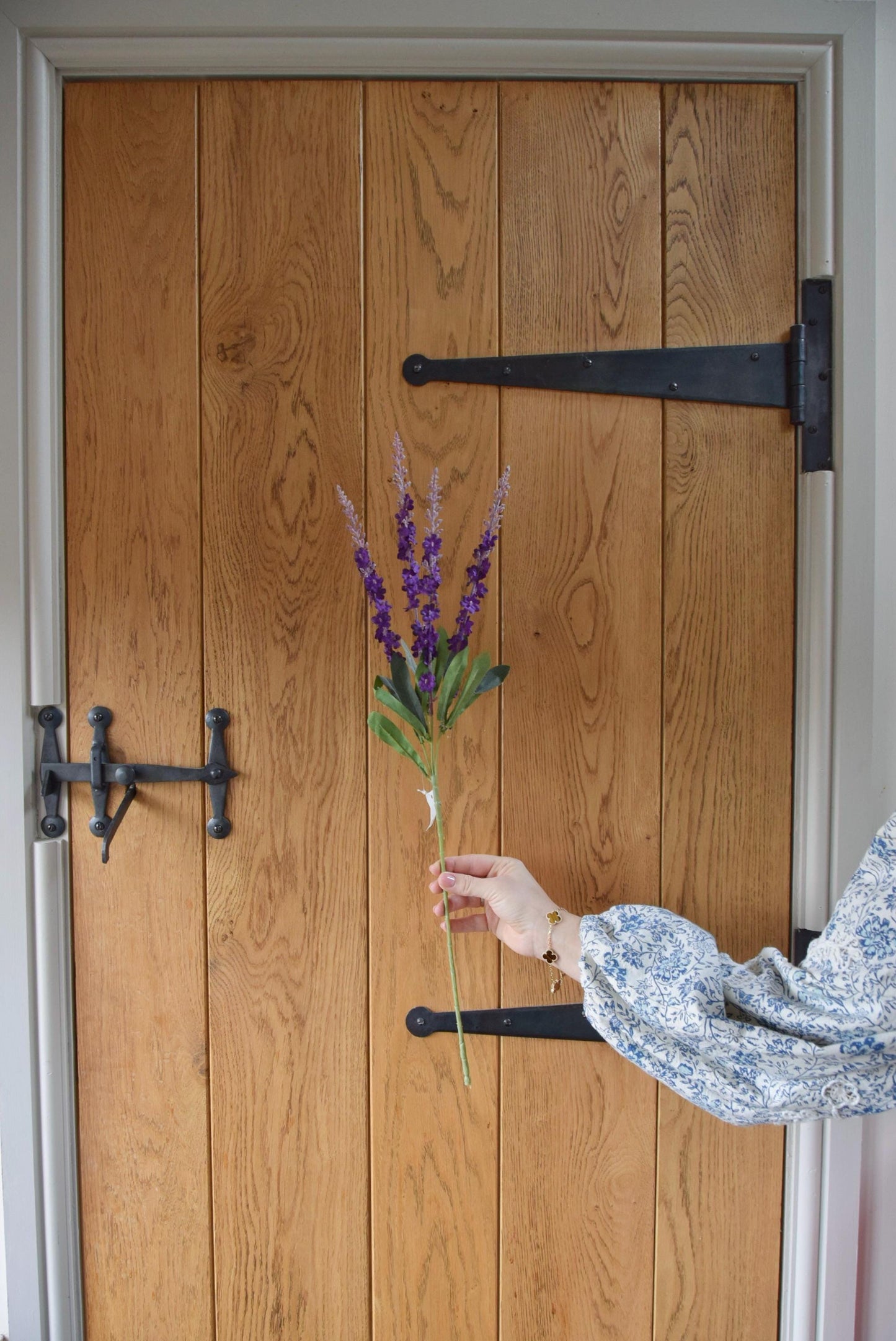 Purple wild flower stems displayed against a country style wooden door.