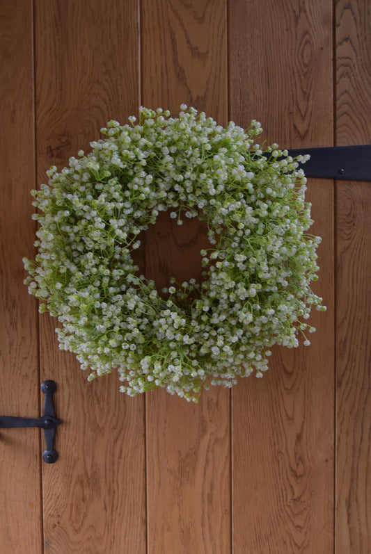White Gypsophila wreath hanging on country style door.