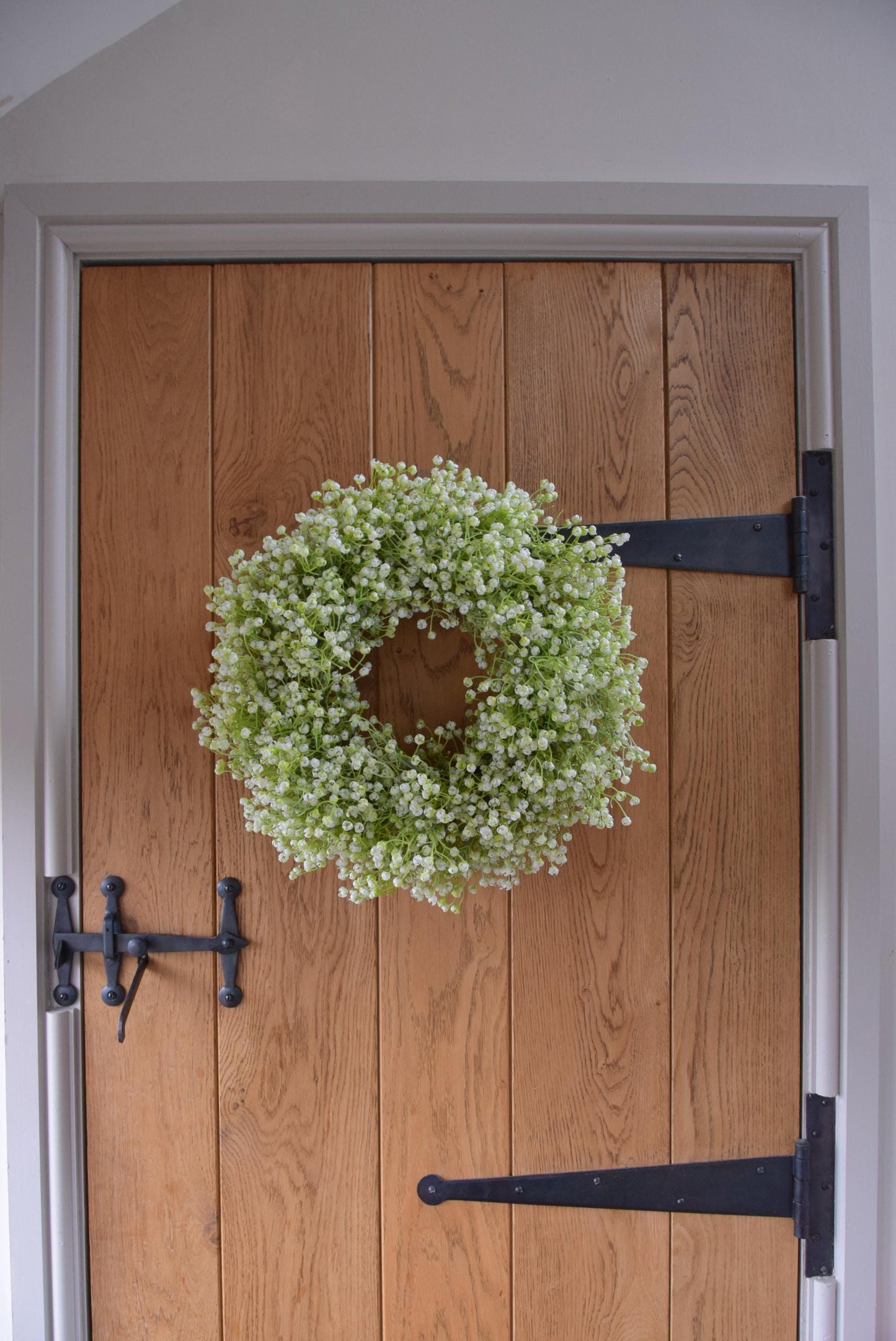 White Gypsophila wreath hanging on country style door.