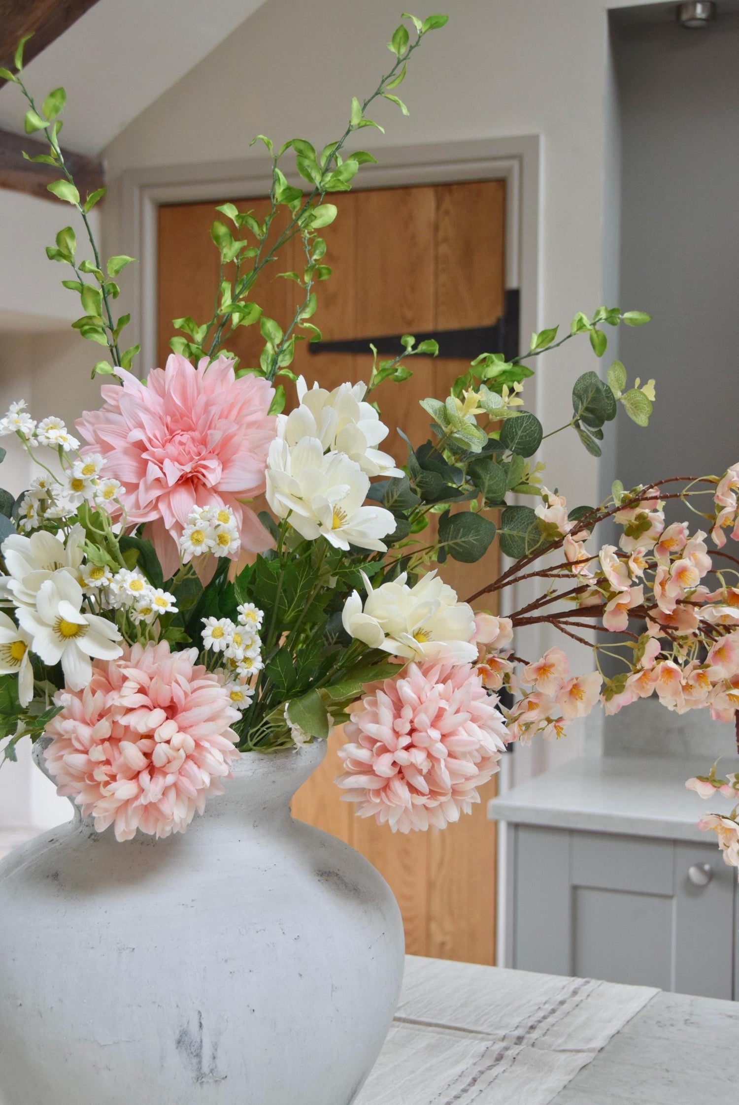 Artificial bouquet of poms, dahlias, blossoms and foliage.