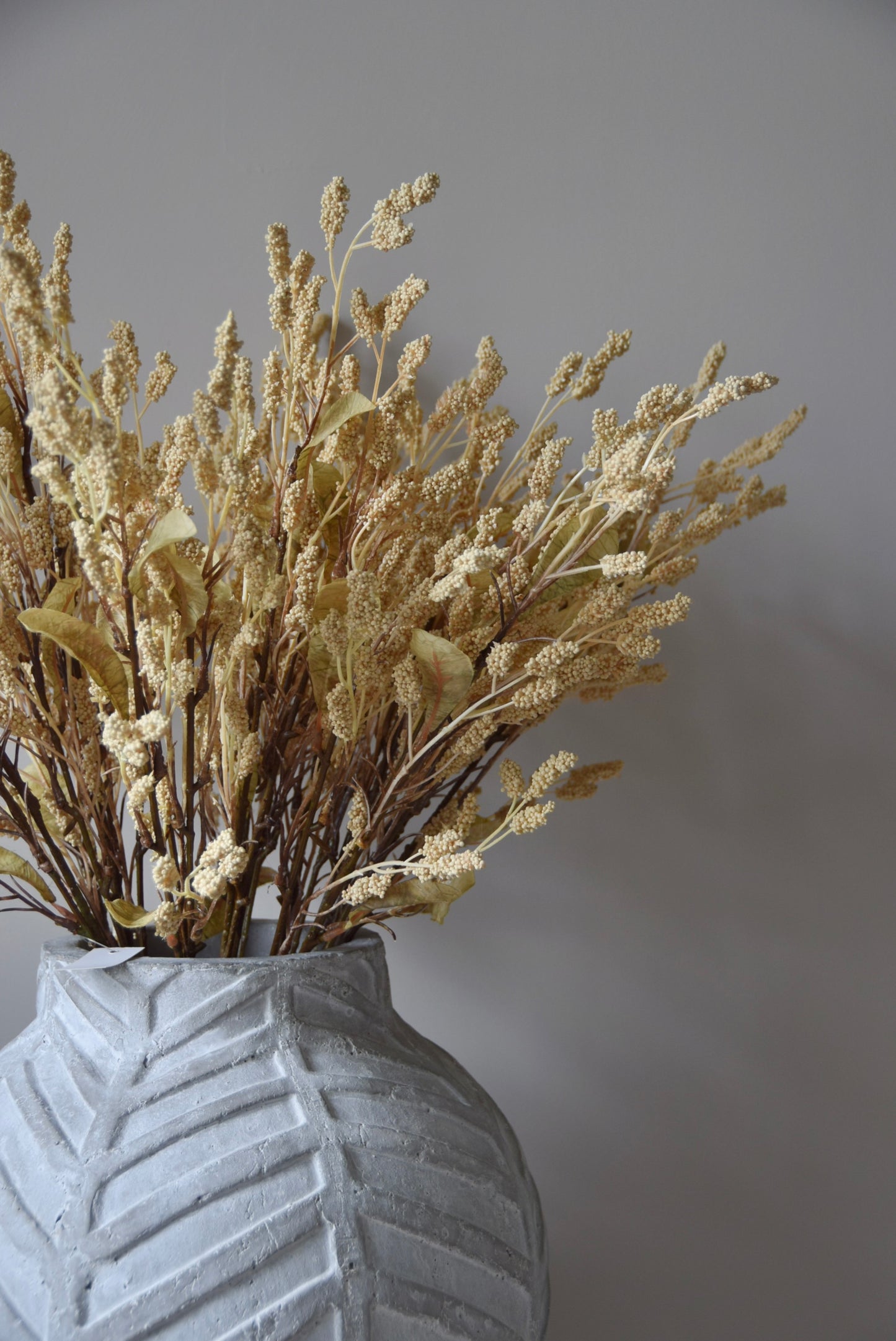 Dried-look grain sorghum spray displayed in a stone chevron style vase.