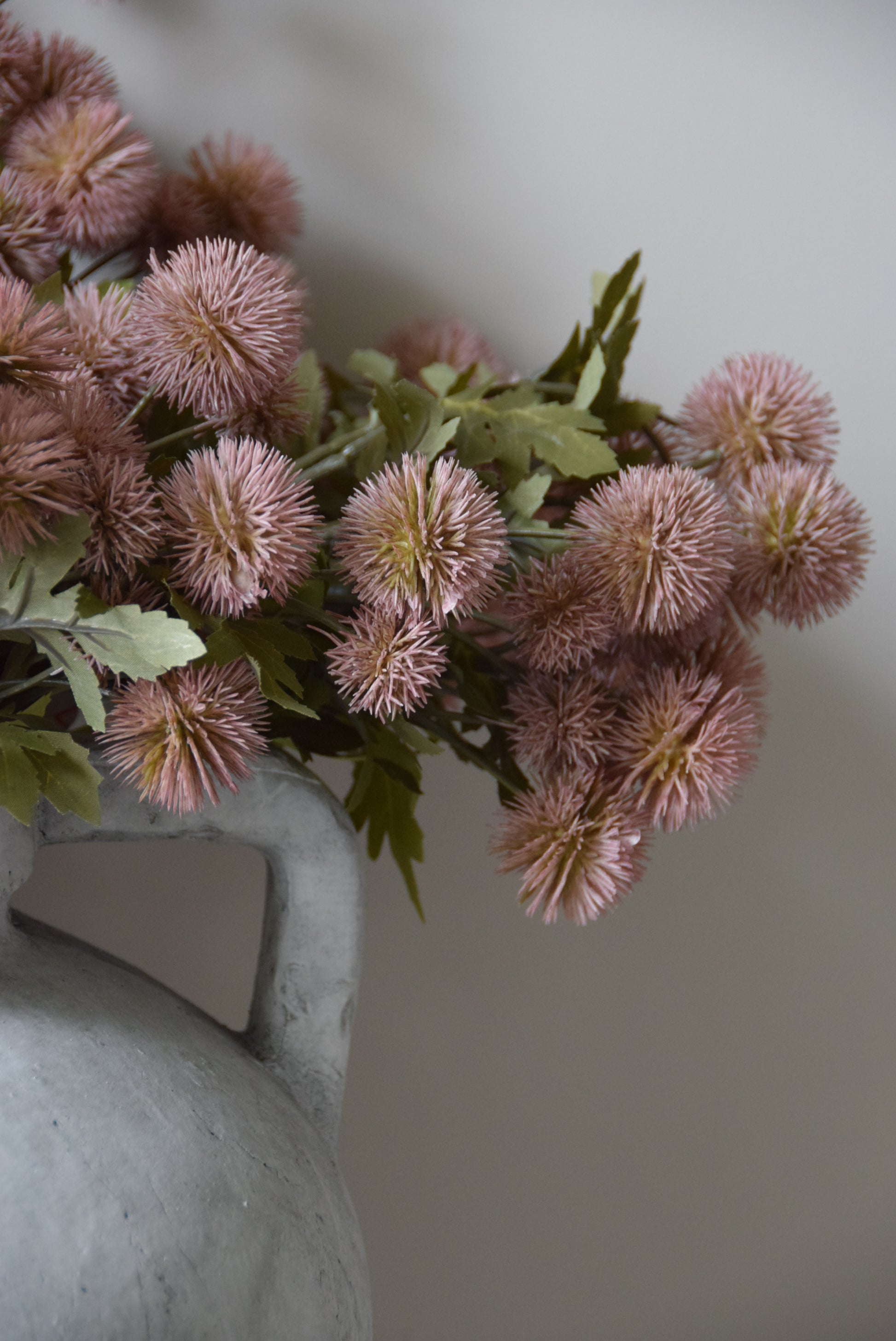 Pink artificial flowers on a gray surface with a neutral background