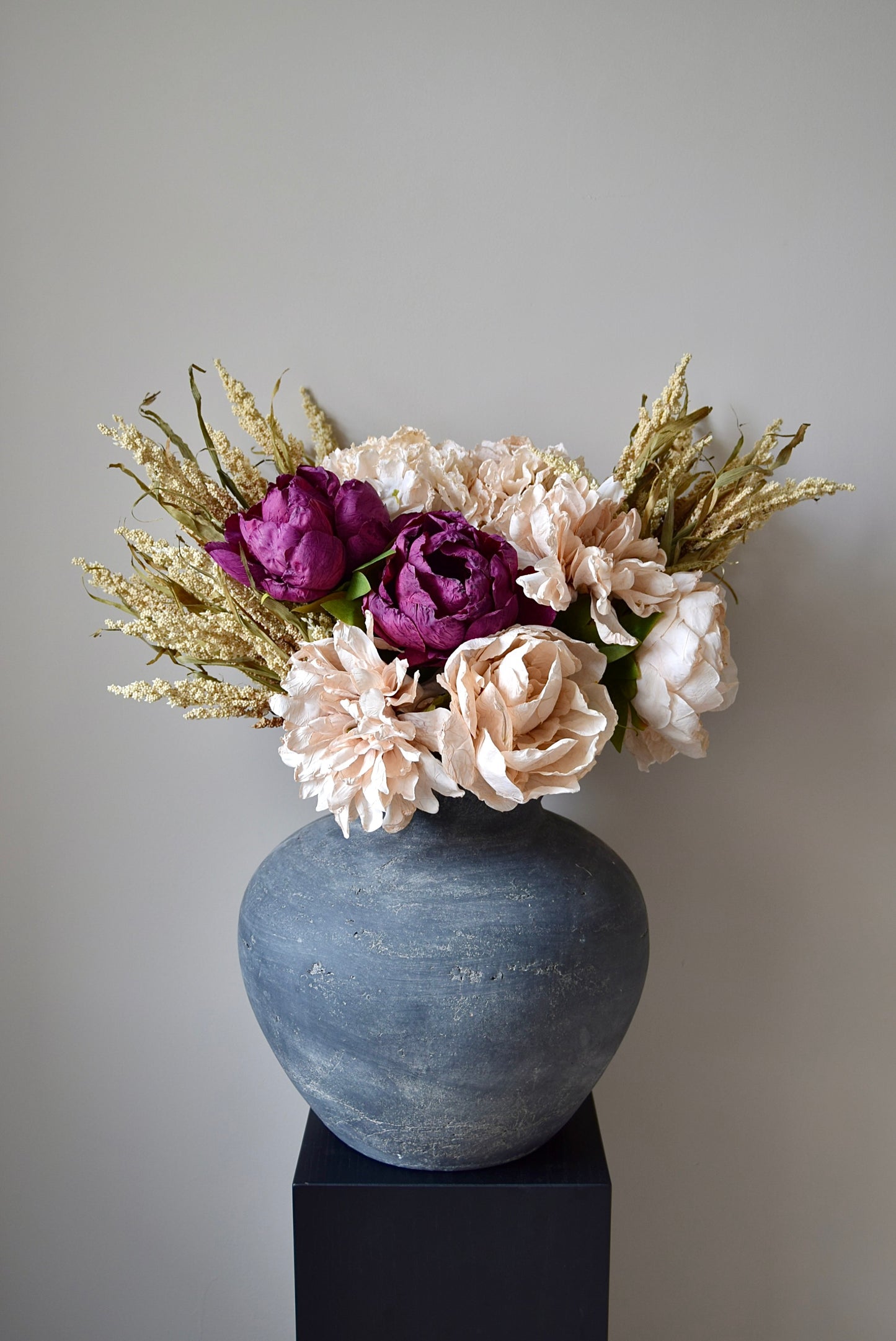 Decorative vase with flowers on a gray background