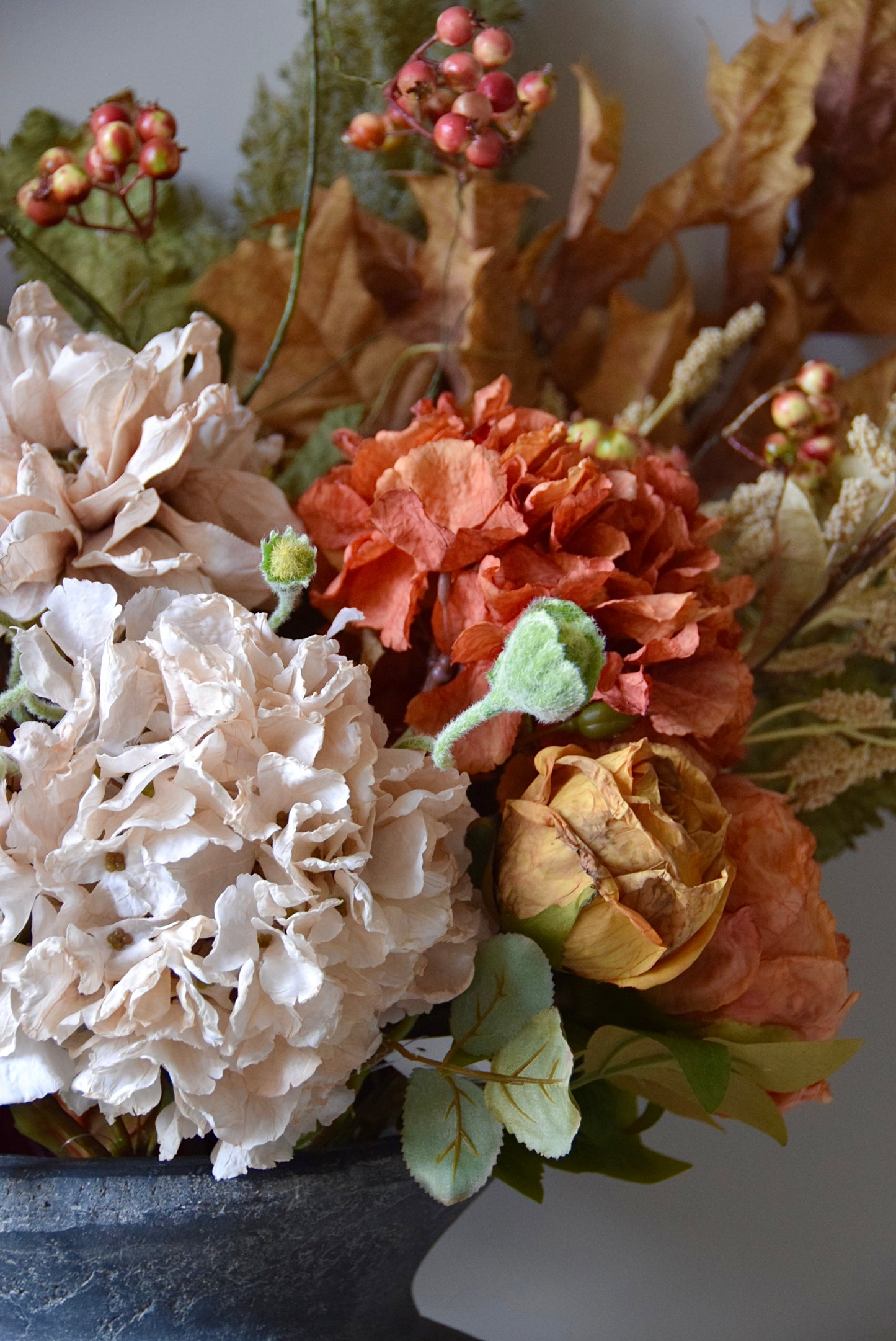 Bouquet of flowers with oyster hydrangeas, honey roses, and green leaves on a neutral background