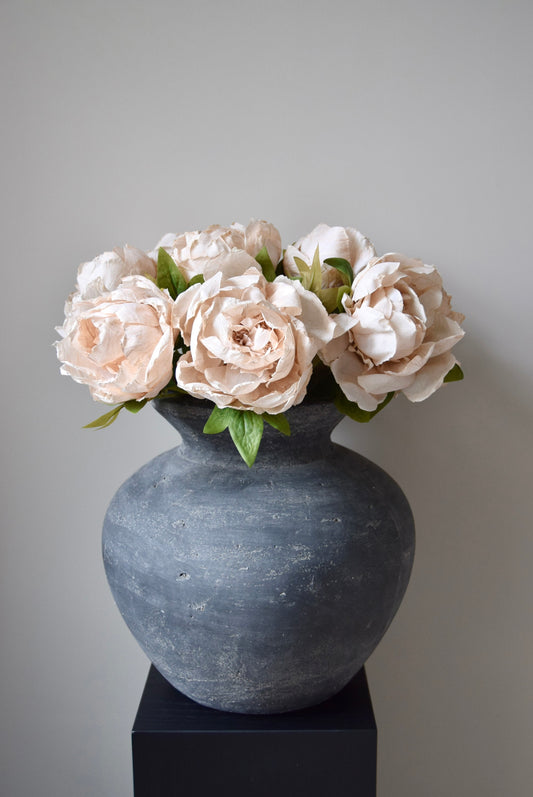 Decorative vase with cream flowers on a grey background