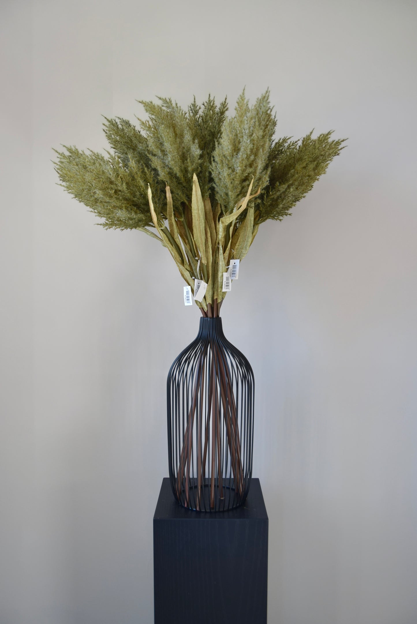 Decorative vase with dried plants on a neutral background