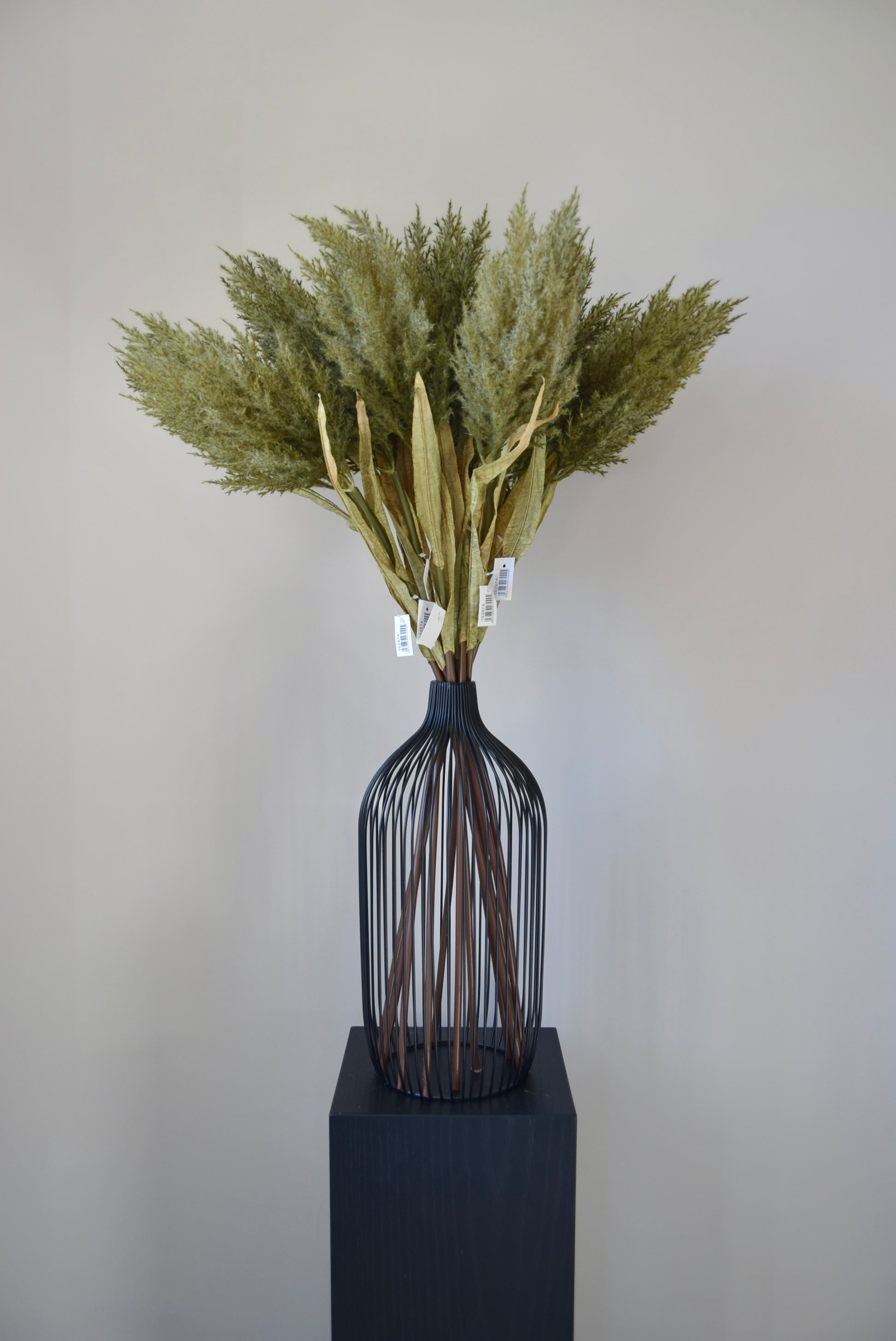 Decorative vase with dried plants on a neutral background