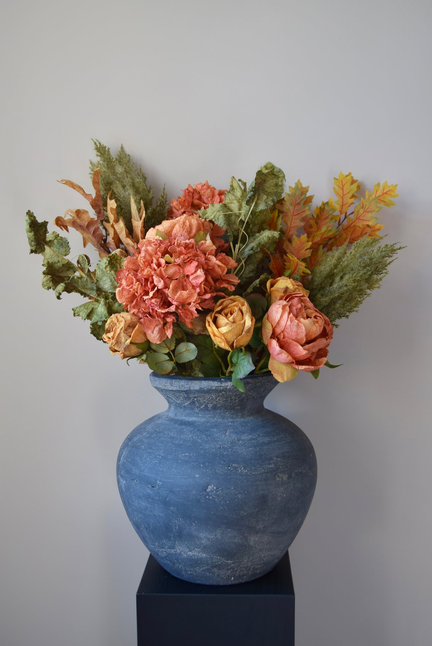 Grey vase with a bouquet of flowers on a white background