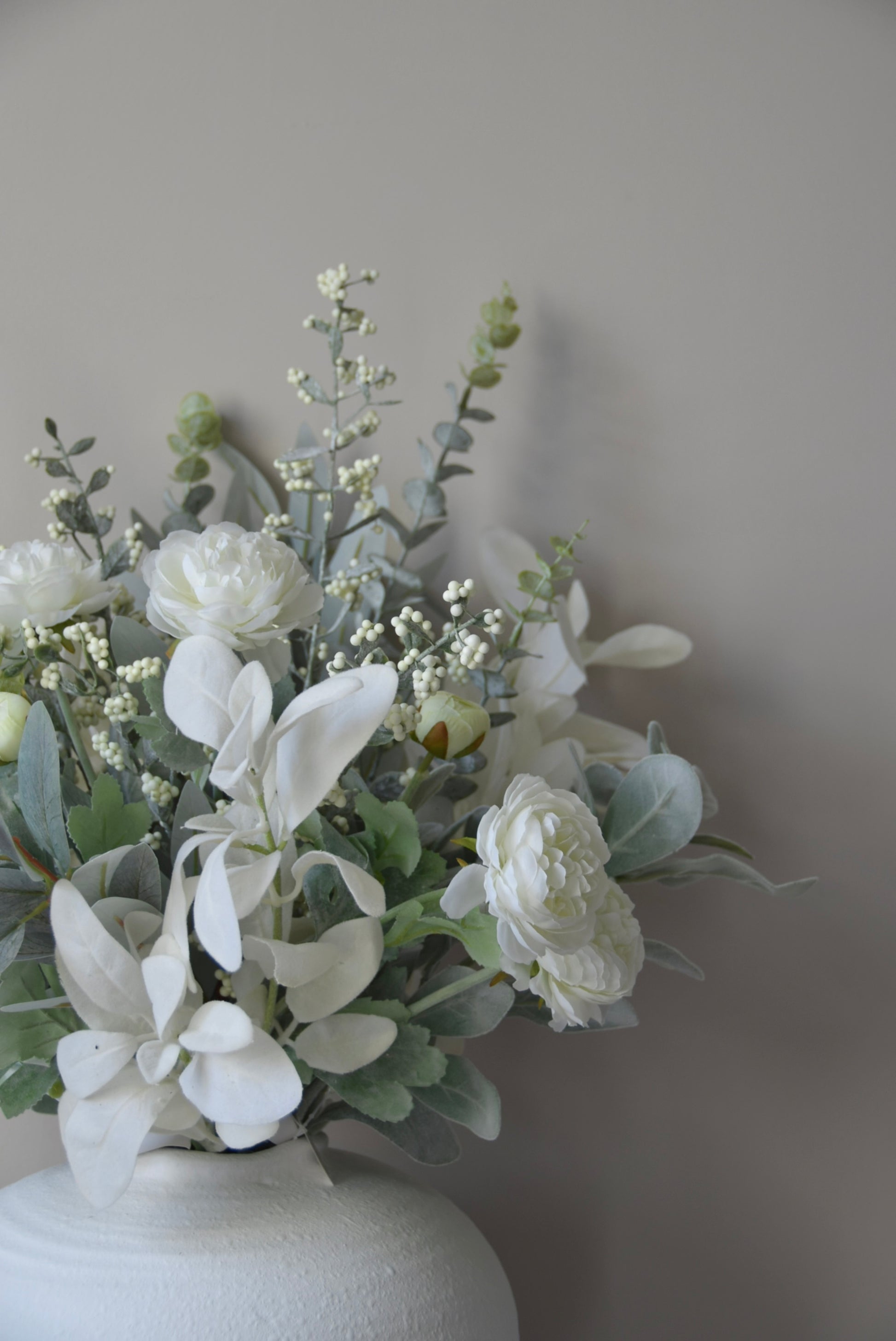 White flowers in a vase against a plain background
