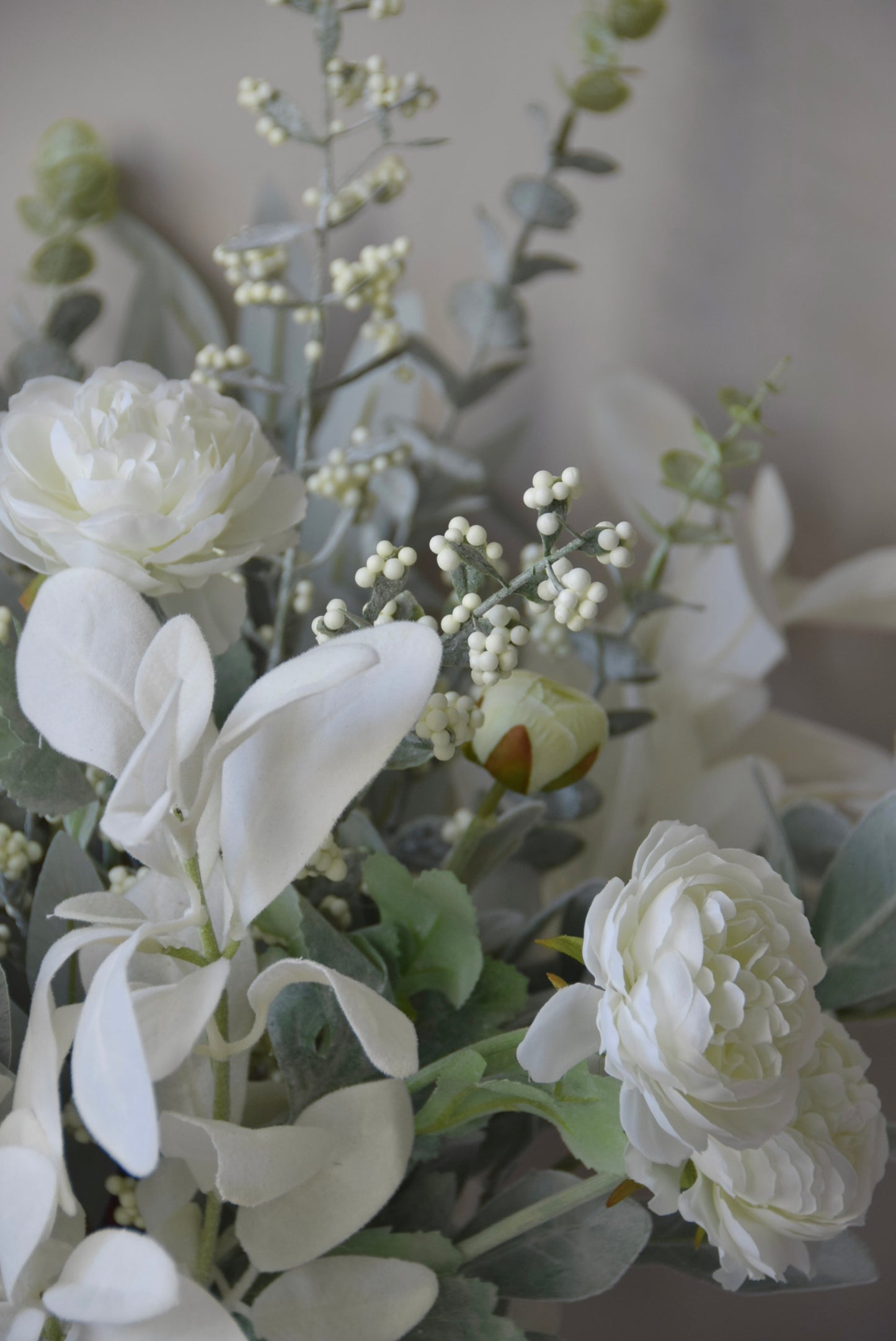 Arrangement of white flowers and greenery with a blurred background