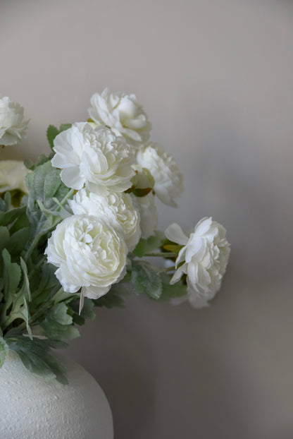White flowers in a vase against a plain background