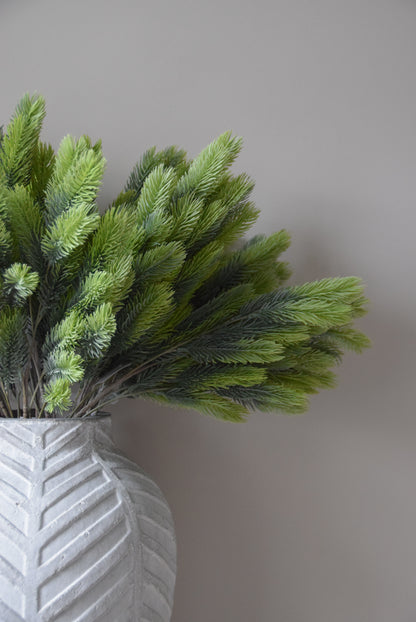 Artificial green spruce against a neutral background