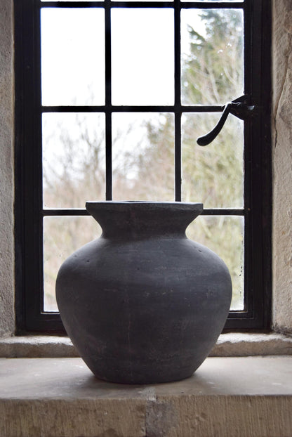 Grey stone vase placed on a stone windowsill in a country style house for home decor