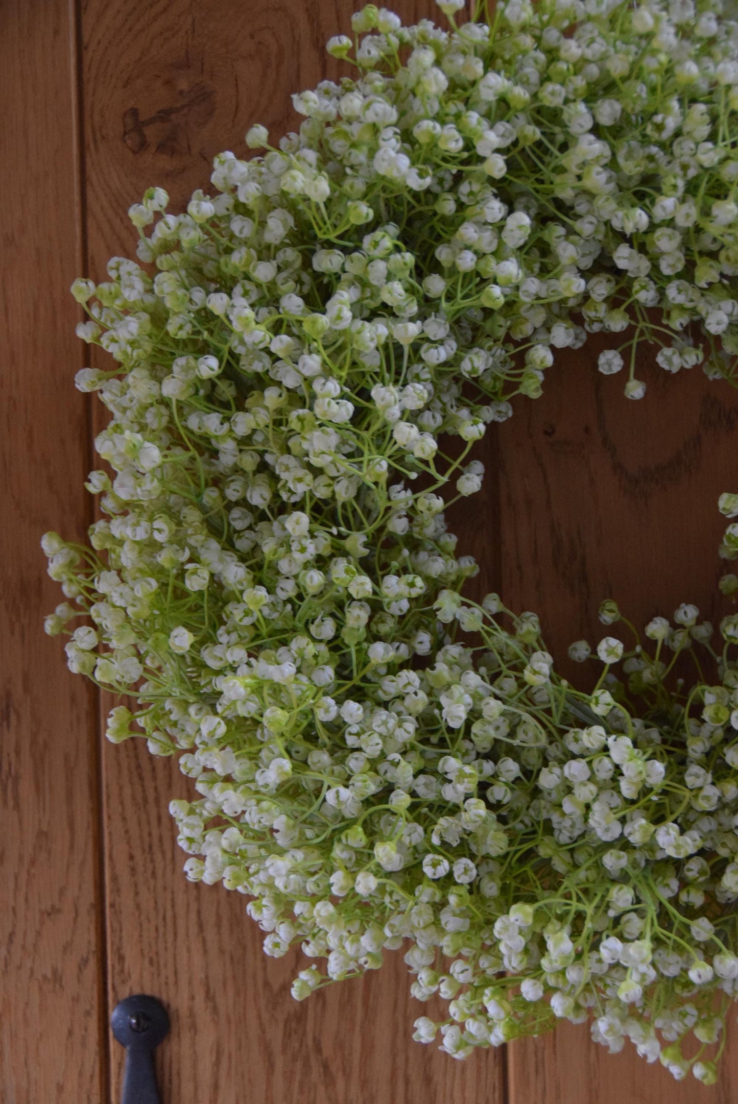 White Gypsophila wreath hanging on country style door.