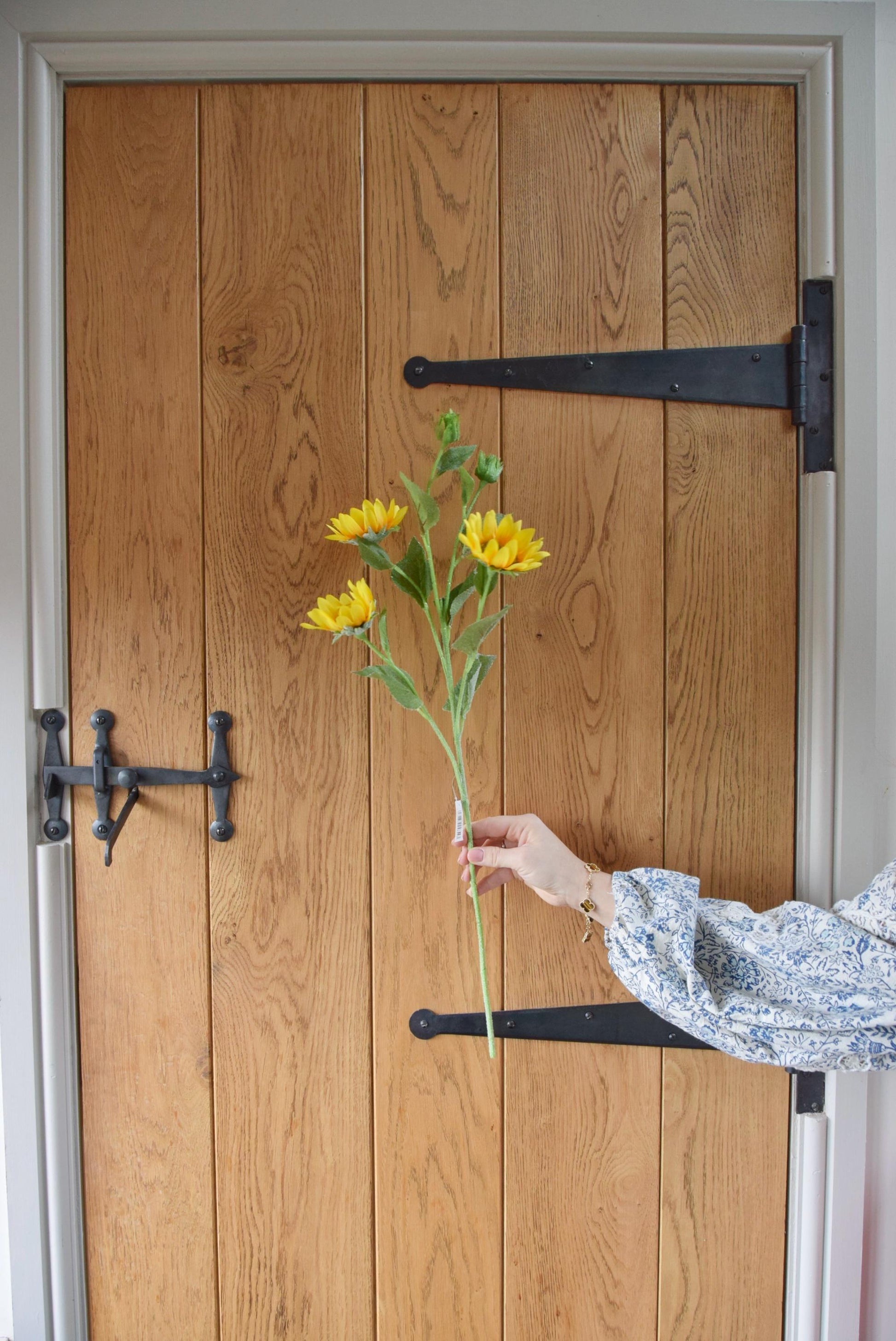 Yellow sunflower spray displayed against a country style wooden door.