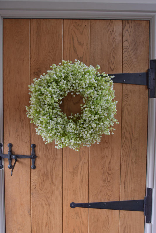 White Gypsophila wreath hanging on country style door.