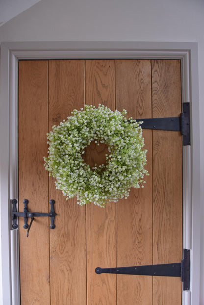 White Gypsophila wreath hanging on country style door.