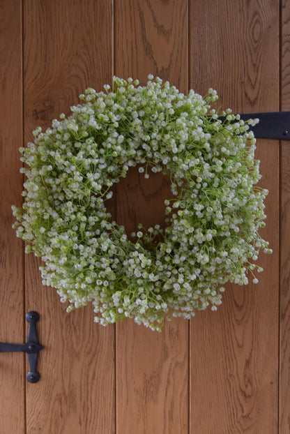 White Gypsophila wreath hanging on country style door.