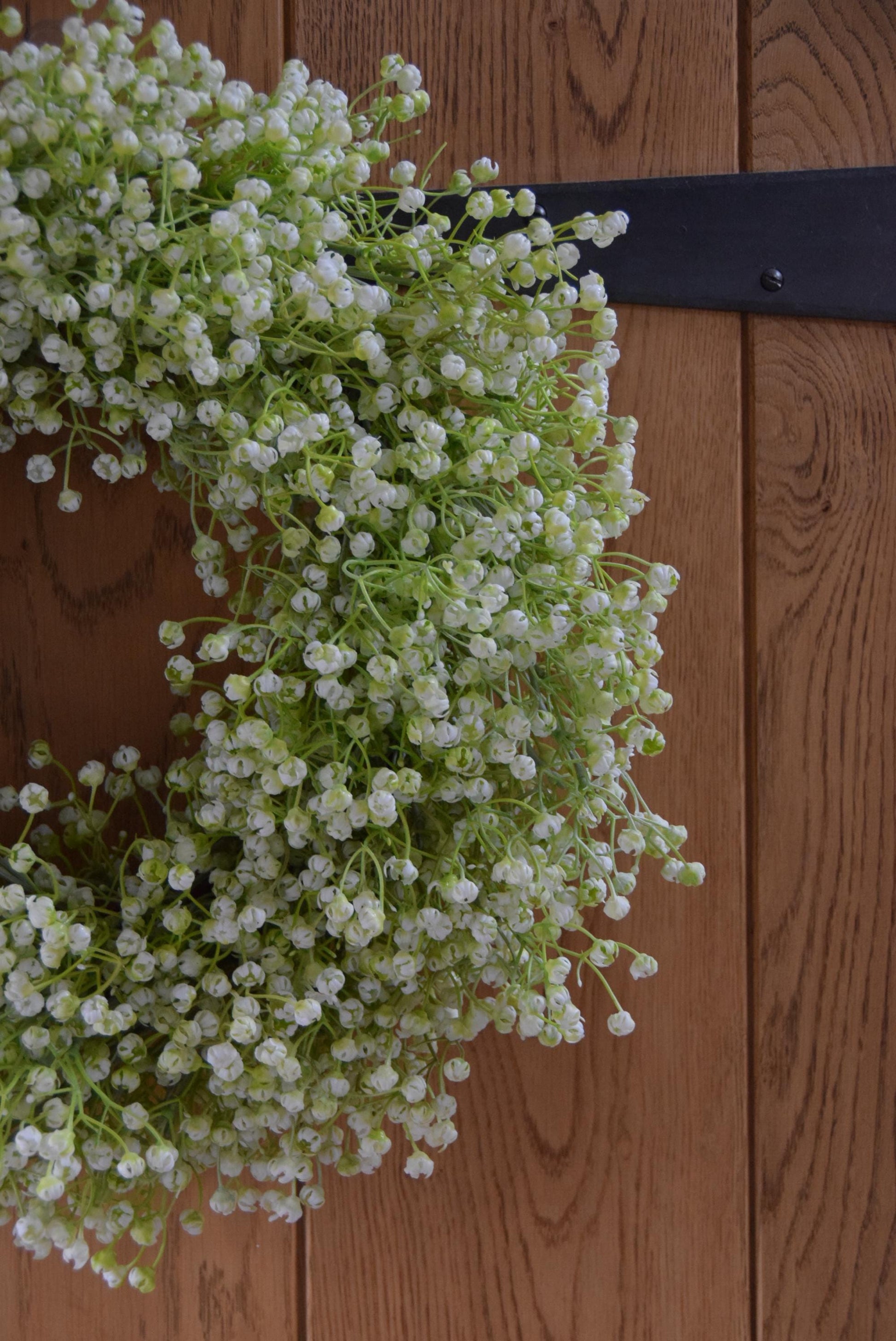 White Gypsophila wreath hanging on country style door.