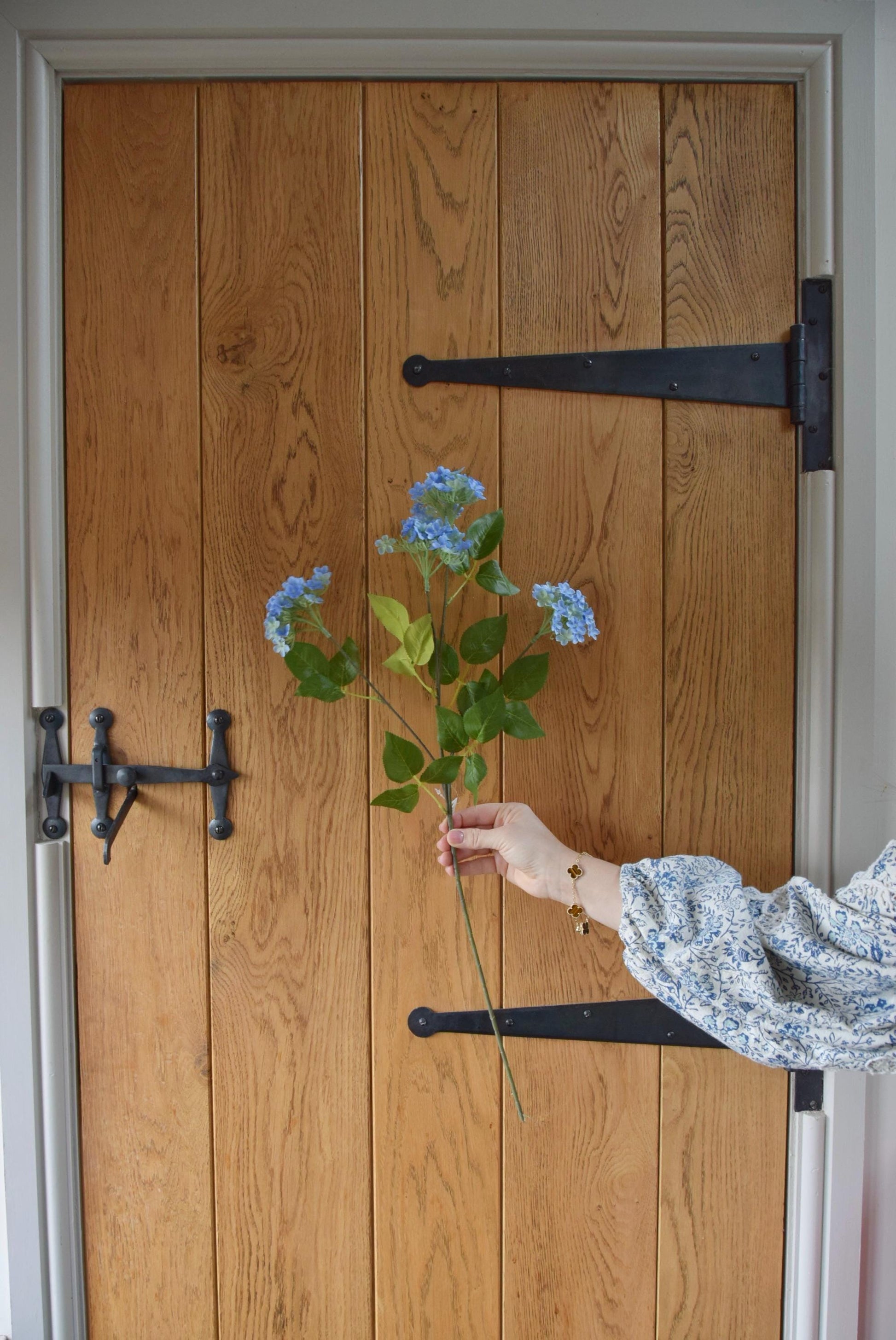 Blue wildflower spray displayed against a country style wooden door.
